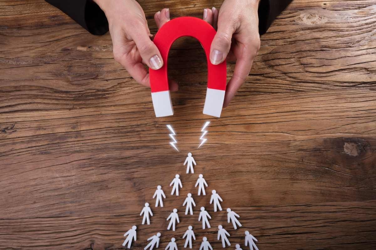 magnet on a wooden table attracting small human-like figures